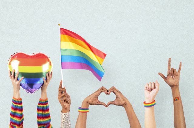 LGBTQ+ pride celebration with hand and crowd cheering